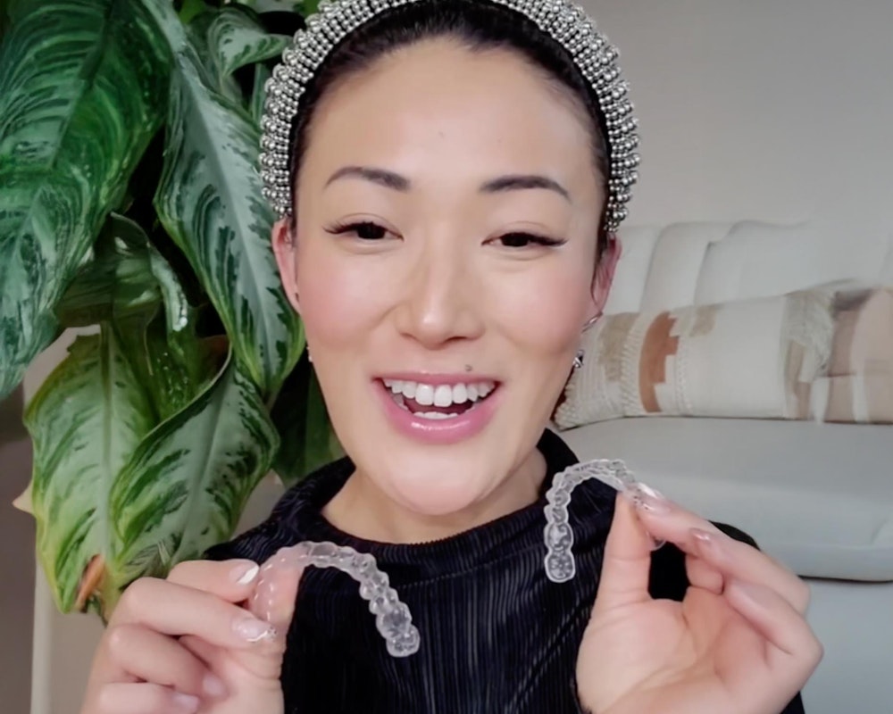 Patient holding clear Invisalign aligners